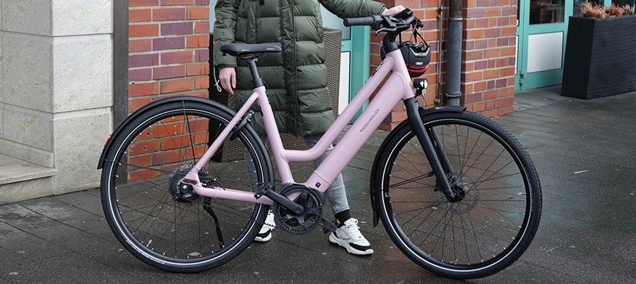 Laura testet das Riese & Müller Culture Mixte Vario und steht mit ihm auf dem Bordstein