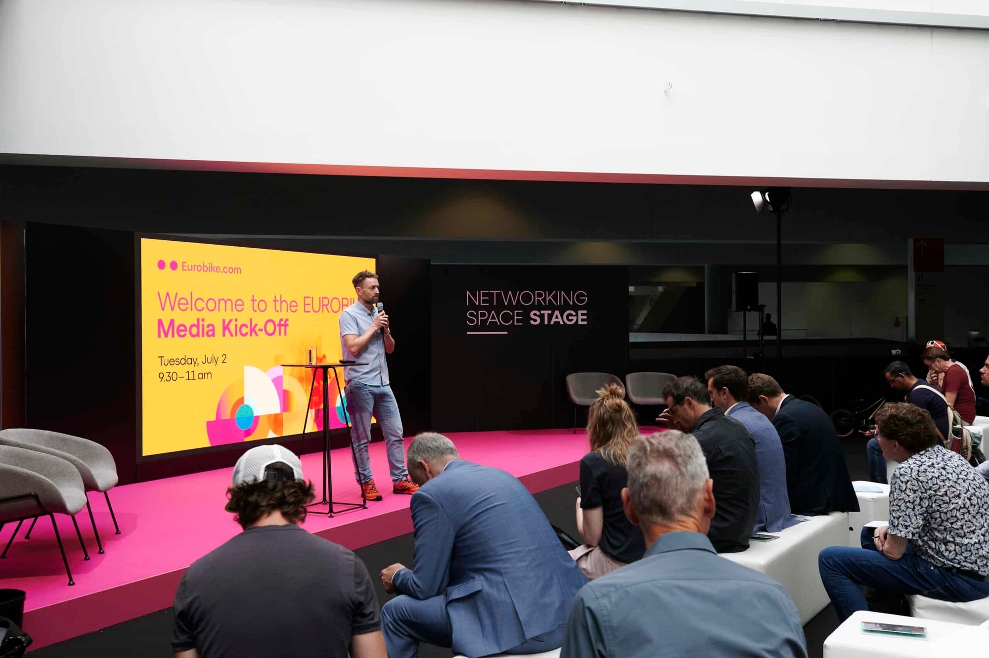 Mann steht auf der Elektrorad Bühne auf der Messe in Essen und hält einen Vortrag.