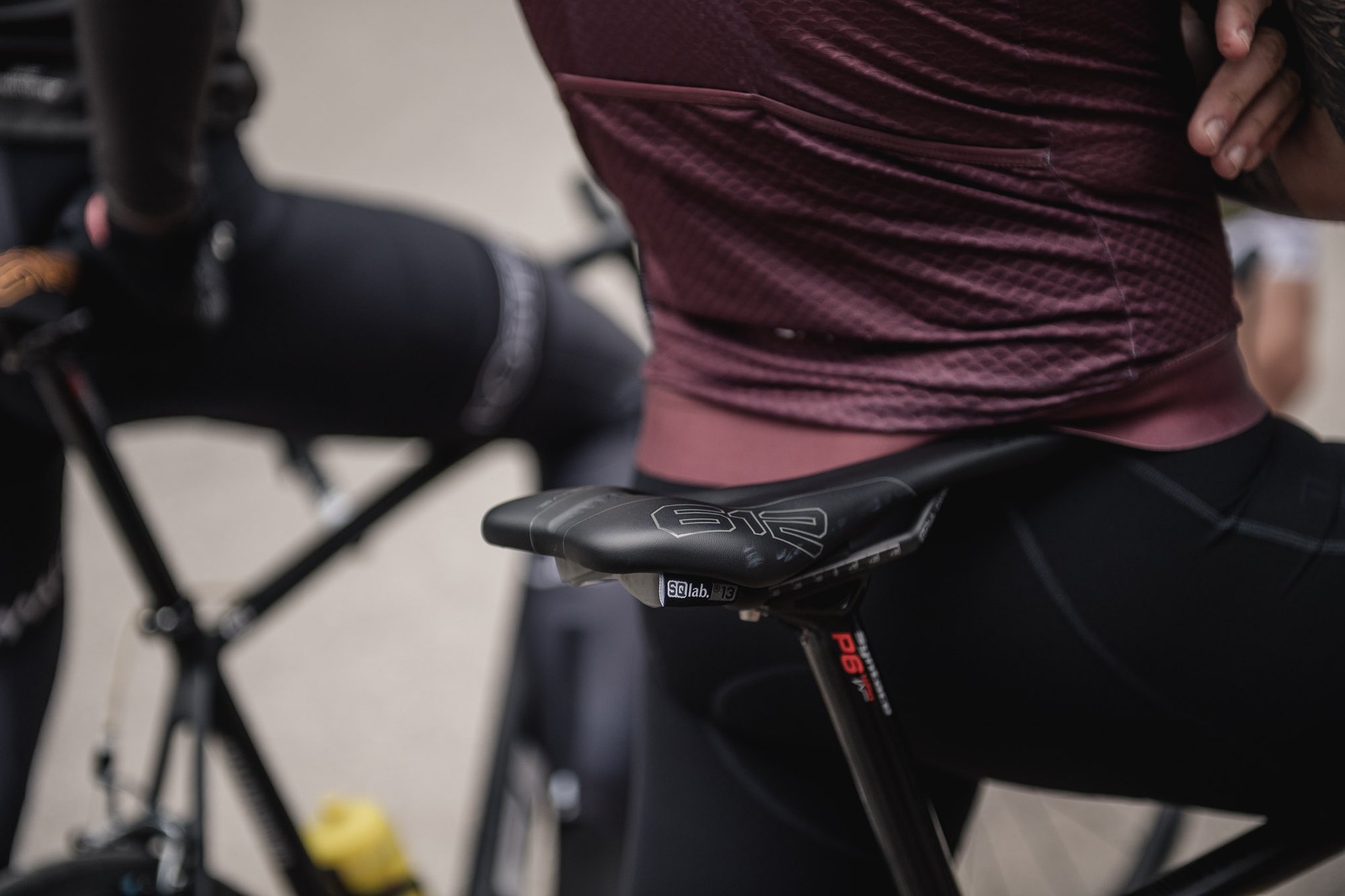 Das Bild zeigt den Nahaufnahme eines Fahrradsattels, auf dem eine Person sitzt. Der Sattel hat ein ergonomisches De