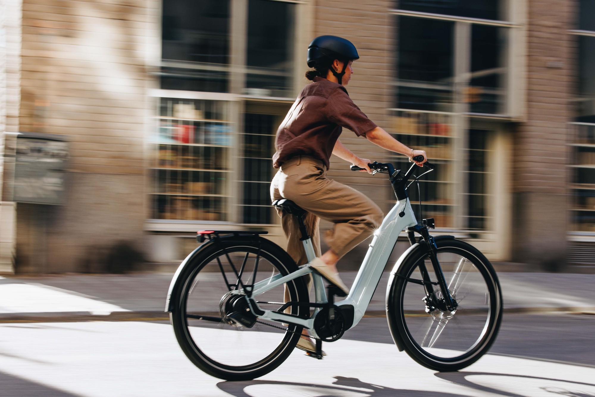 Das Bild zeigt ein Specialized Como E-Bike, das von einer Person in moderner Bekleidung gefahren wird.