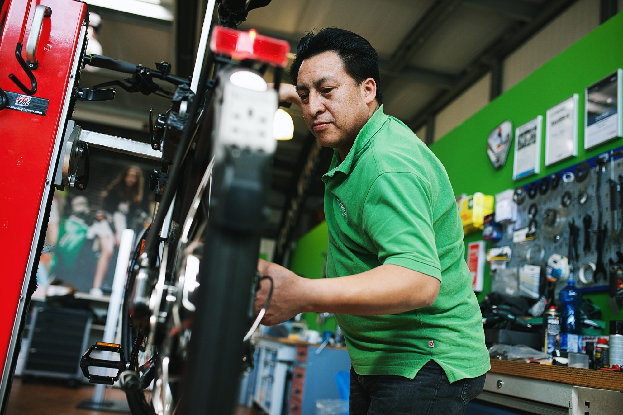 Mitarbeiter repariert ein Fahrrad in der neuen e-motion e-bike Welt in Düsseldorf.