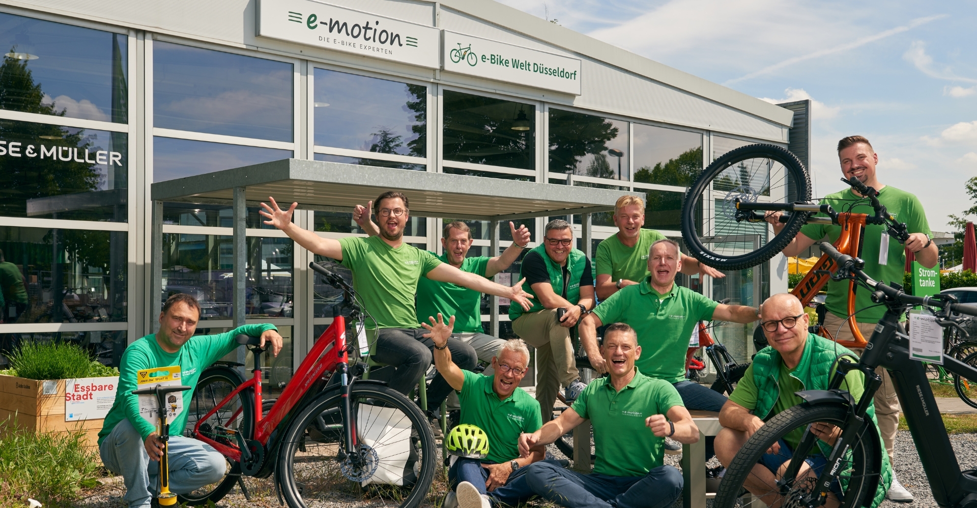 Das Verkaufsteam der e-motion e-Bike Welt Düsseldorf posiert vor dem Shop