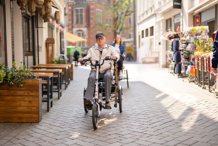 Ein Senior fährt mit einem Dreirad in den Urlaub