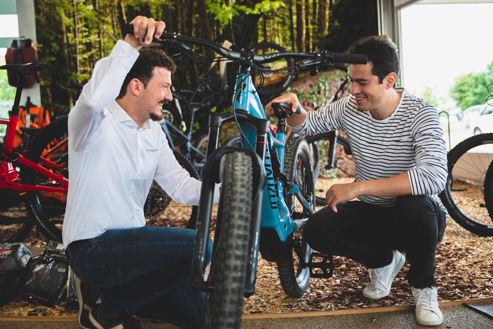 Zwei Personen sitzen vor einem e-Bike und schauen sich die Ergonomie des Bikes an