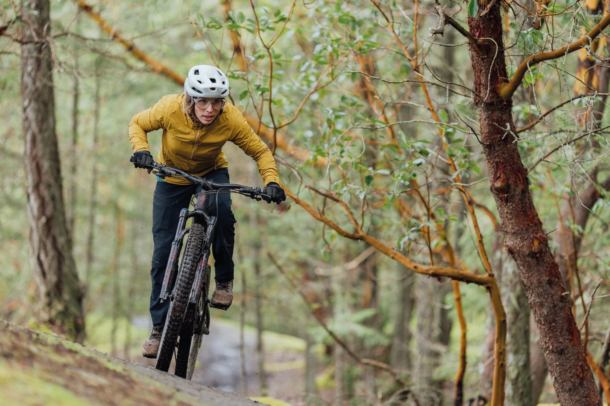 Eine Mountainbikerin fährt auf dem Specialized Turbo Levo e-Mountainbike einen Hang hinunter.