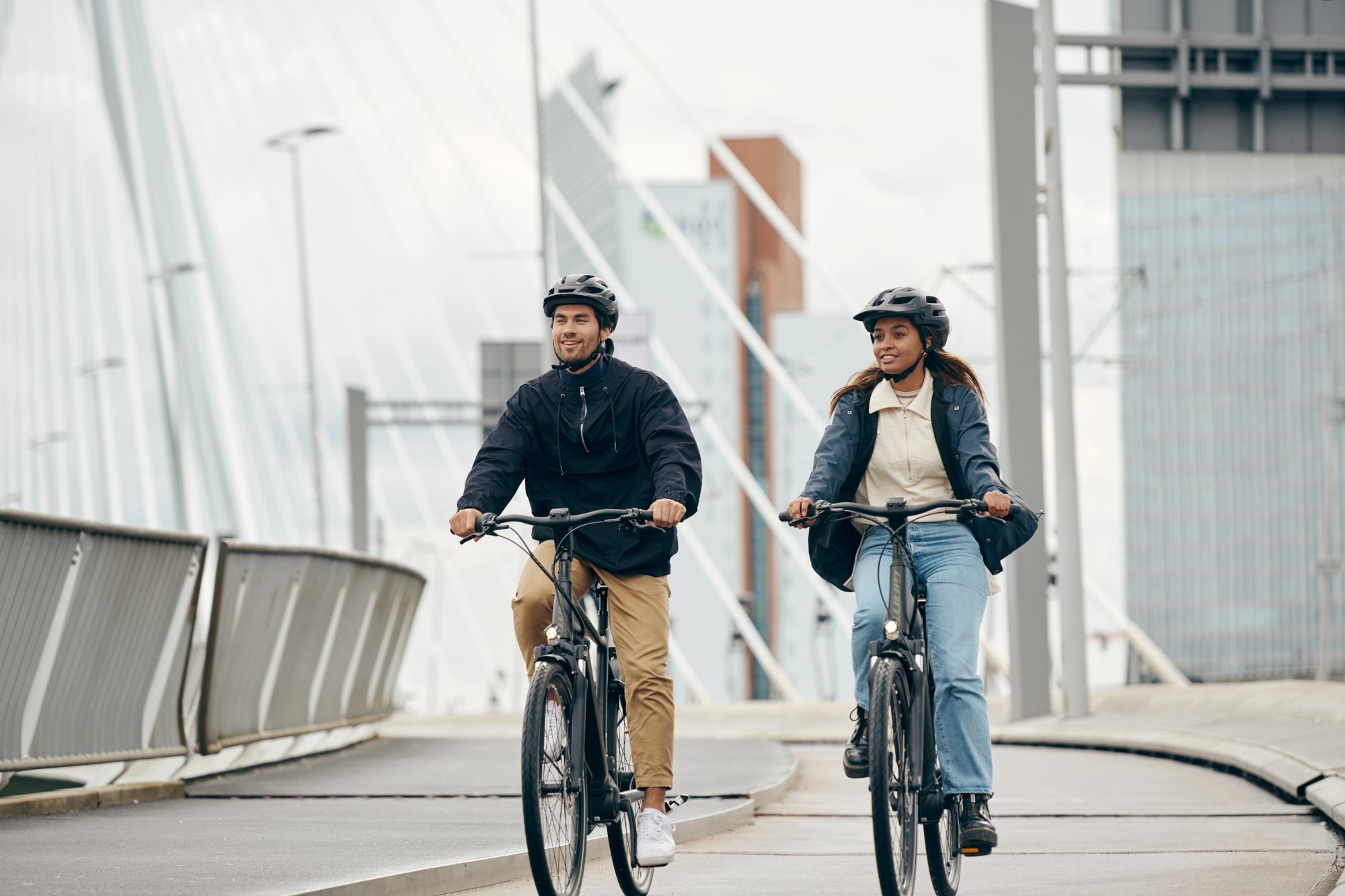 Ein Mann und eine Frau fahren über eine Brücke mit Giant e-Bikes